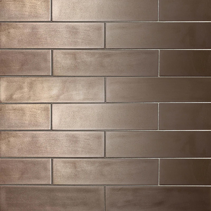 Bronze ceramic wall tile in a staggered brick layout, 10.5 × 2.5 inches.