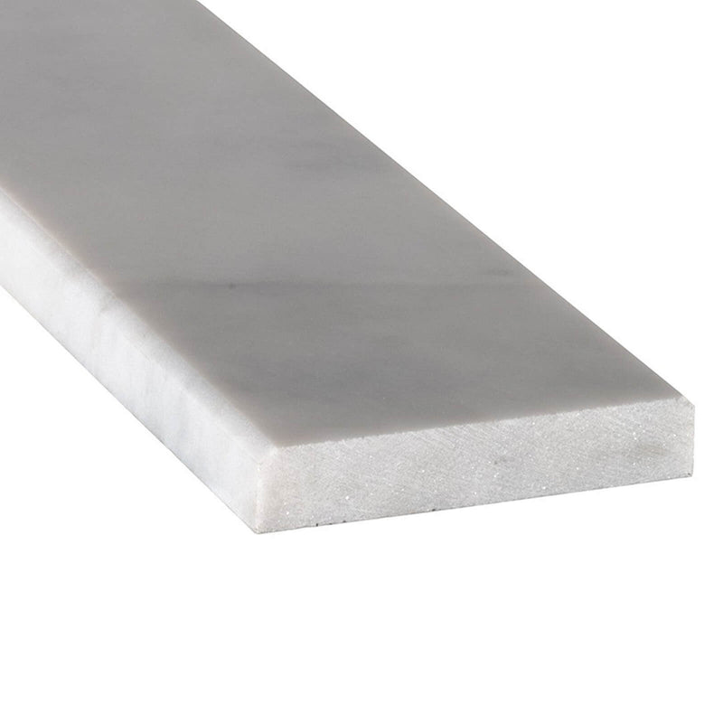 Close-up of Turkish Carrara 6x72 polished marble window sill trim showing its white surface and beveled edge.