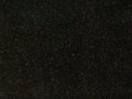 Close-up of dark Ubatuba granite with subtle green, gold, and gray mineral flecks.