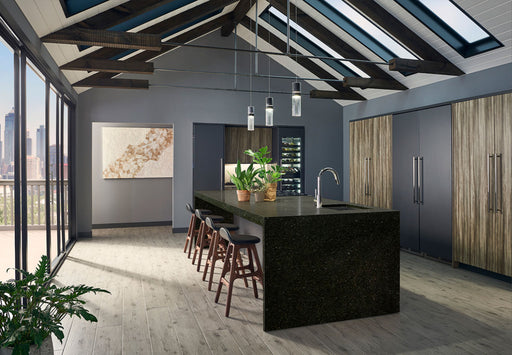 Ubatuba granite kitchen island in a modern kitchen with wood cabinetry and skylights.