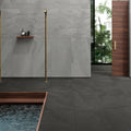 Rail Black matte porcelain tiles on the floor of a modern bathroom with gray tiled walls.