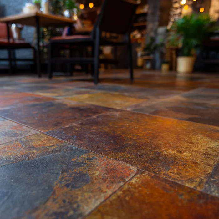 Charcoal stone-look plank kitchen floor beneath island and natural-wood cabinetry with tall windows
