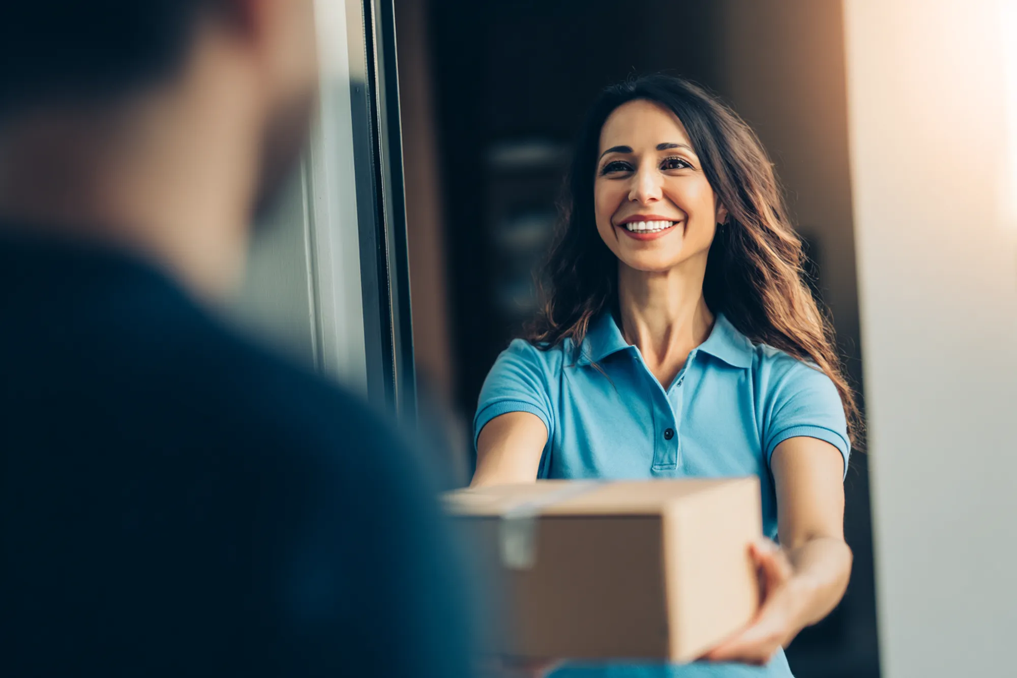 Friendly courier in a modern uniform returning a package
