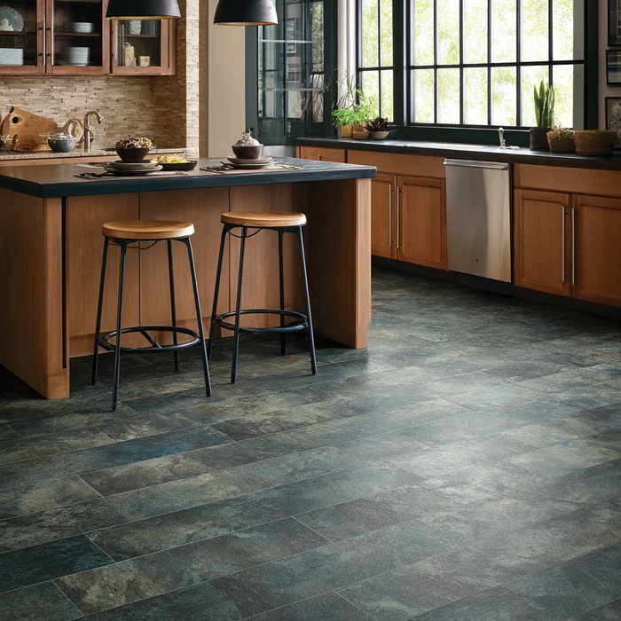 Charcoal stone-look plank kitchen floor beneath island and natural-wood cabinetry with tall windows
